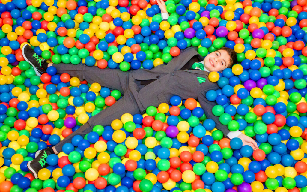toronto-bar-mitzvah-fun-party-photob Bar mitzvah boy lying in a colourful ball pit during his celebration