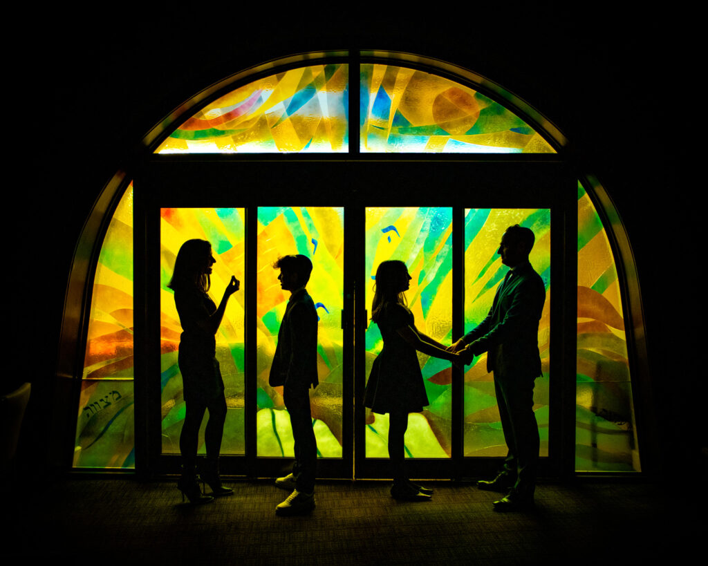 toronto-mitzvah-stained-glass-silhouette Mitzvah family silhouetted against colourful synagogue stained glass